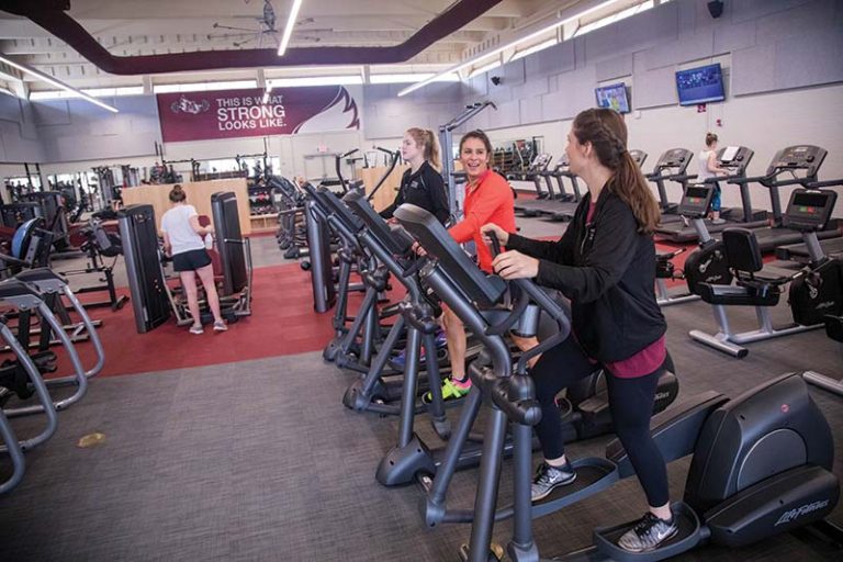 Three students on treadmills in campus fitness center