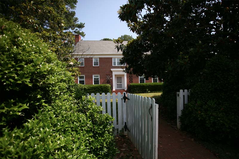 Ellen Brewer house with a white gate and fence in front.