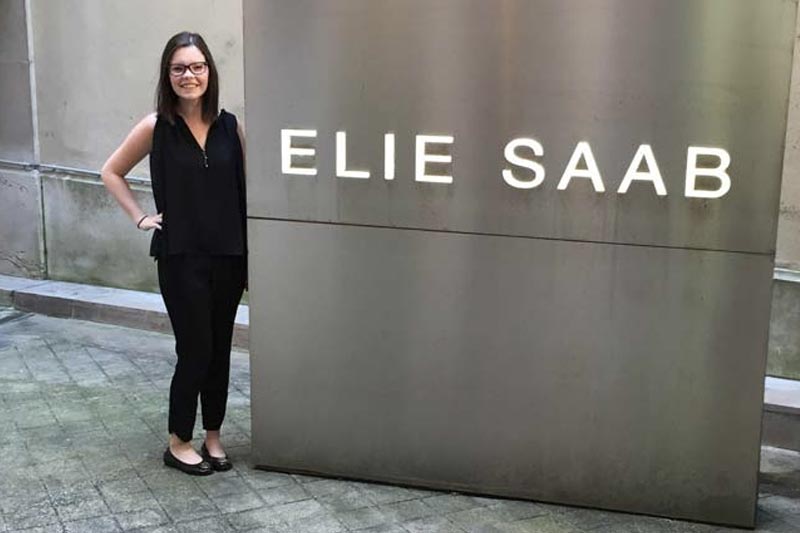 A student standing with a "Elie Saab" sign.