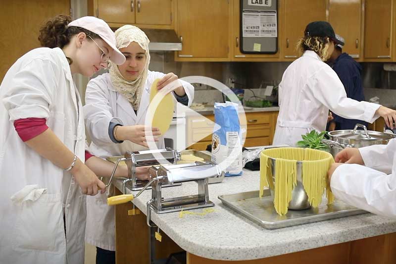 click photo of students preparing meals to play Hospitality Management Video in modal