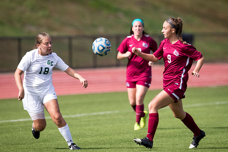 Two Meredith College soccer student-athletes going after the ball in a game.