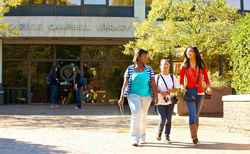 students walking in front of library