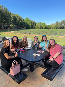 A group of students sitting at a picnic table at the Eno River Farm.