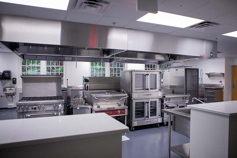 A brand new food lab with stoves, fridges, and tables.