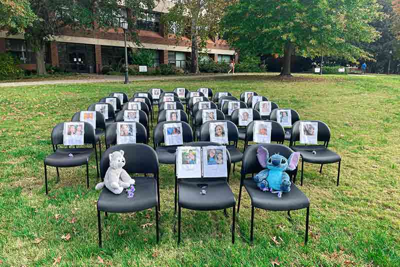 Chairs on the lawn with images and descriptions of people.