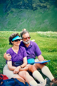 A couple smile for a photo in green hills on an abroad program.