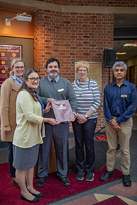 Five people with an award at the articulation agreement signing for our pre-health program with West Virginia University medical school.