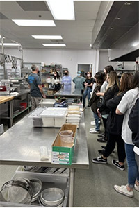 Students listen during a tour of the kitchen at Rocky Top Catering.