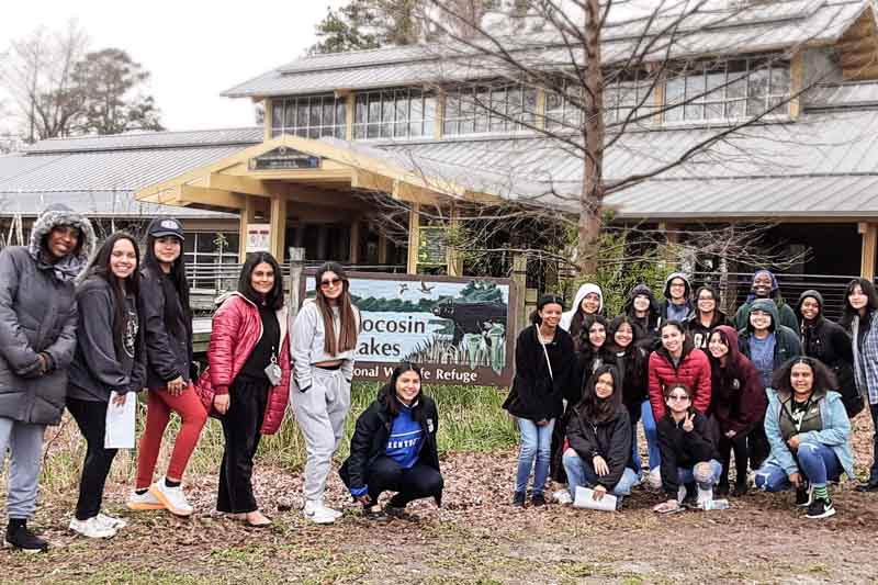 A group of students smiling at a wildlife refuge.