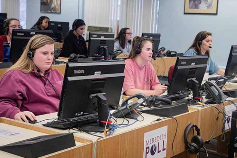 Students run the phones and computers for the Meredith poll.