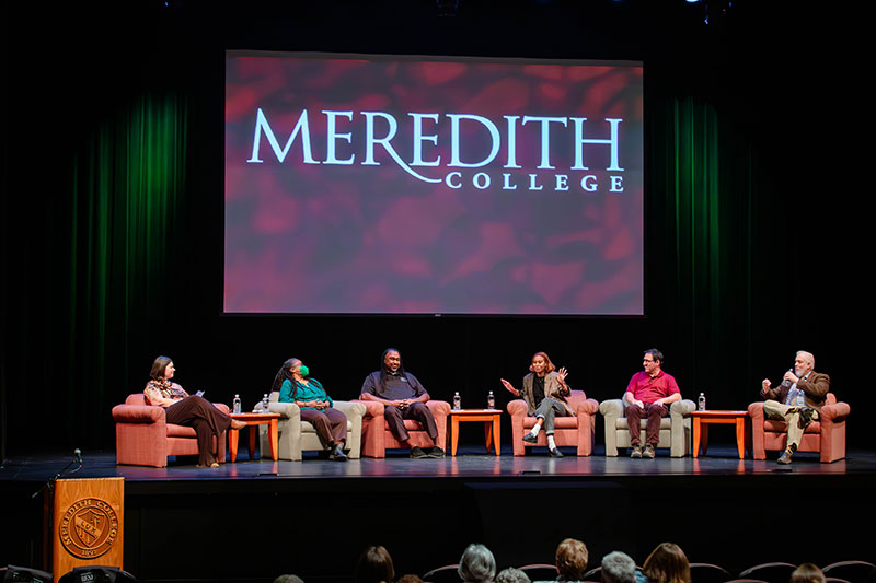 Six panelists sit on stage with Meredith College wordmark on screen in background