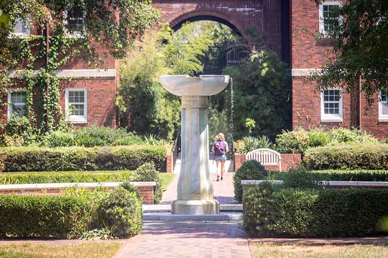 The Meredith fountain and a student walking to class in the background.